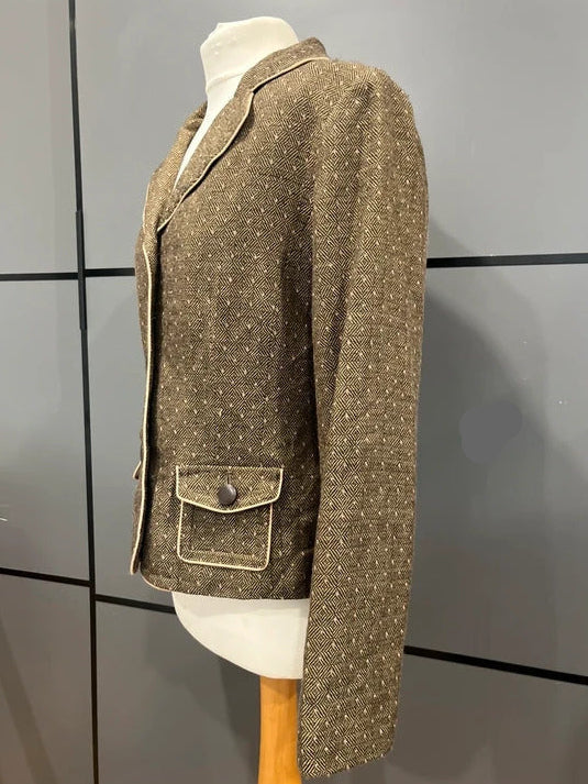 A brown tweed blazer with a subtle speckled pattern, displayed on a white mannequin torso. The blazer features notch lapels, a single-breasted button closure, and a front flap pocket with a button detail.